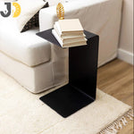 Load image into Gallery viewer, طاولة جانبية معدنية سوداء بتصميم حرف C بجانب الأريكة
Black metal C-shaped side table beside sofa