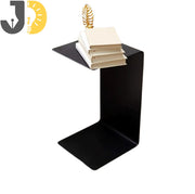 طاولة جانبية معدنية سوداء بتصميم حرف C بجانب الأريكة
Black metal C-shaped side table beside sofa