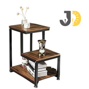 طاولة جانبية خشبية معدنية بثلاث مستويات بجانب السرير في غرفة عصرية
Wood and metal three-tier side table beside bed in modern bedroom