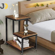طاولة جانبية خشبية معدنية بثلاث مستويات بجانب السرير في غرفة عصرية
Wood and metal three-tier side table beside bed in modern bedroom